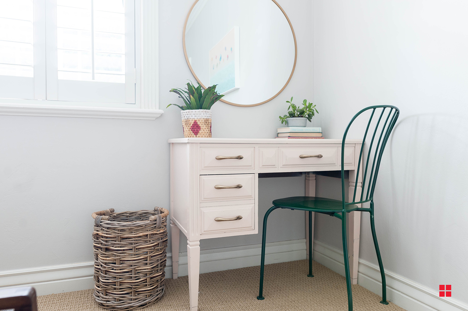 Pale pink desk with a green chair. 