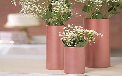 Shimmery metallic vases with flowers in them.