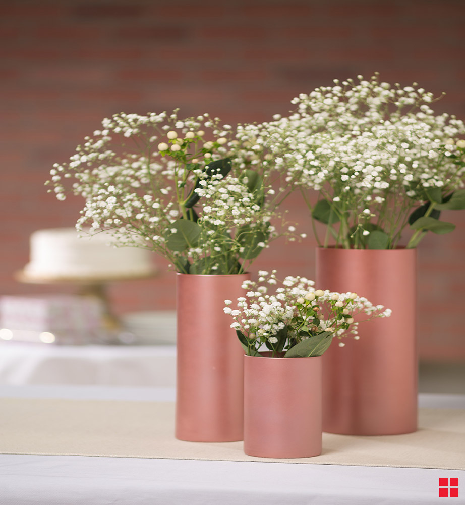 Shimmery metallic vases with flowers in them.