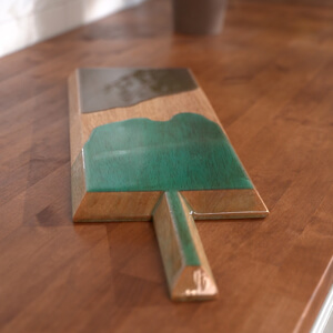: Charcuterie board decorated with epoxy resin in two colors.