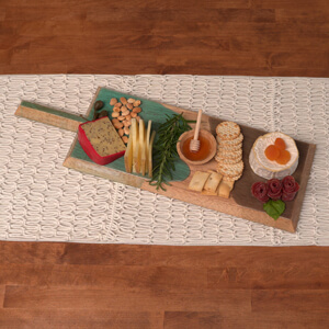 Charcuterie board with epoxy resin coating filled with snacks on a table.