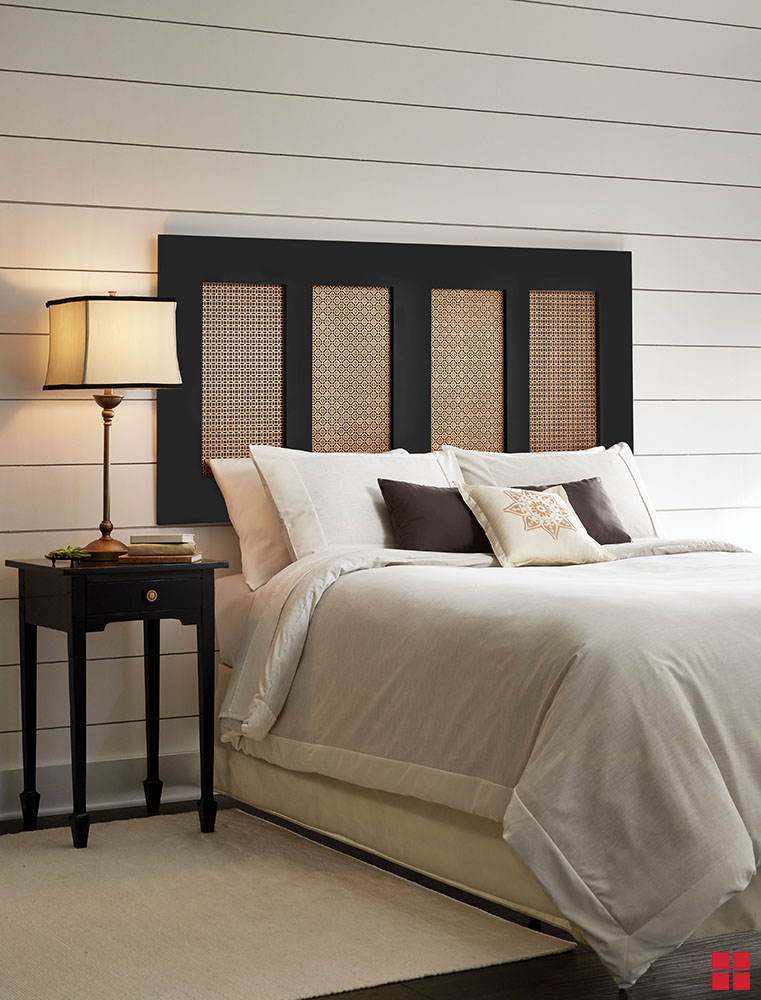 Black and copper wall-mounted headboard behind a bed. 