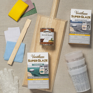 Bare charcuterie board, boxes of Varathane Super Glaze and a can of Watco butcher block oil.